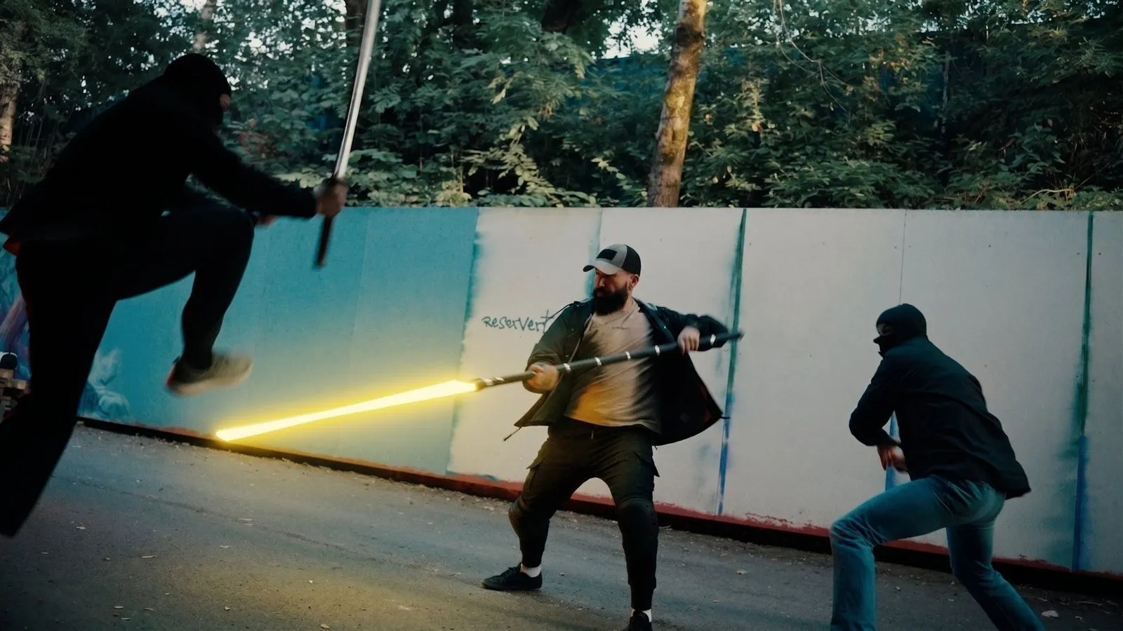 Stillbilde fra en lyssabelvideo: et gult blad og et flyvende spark under en bro